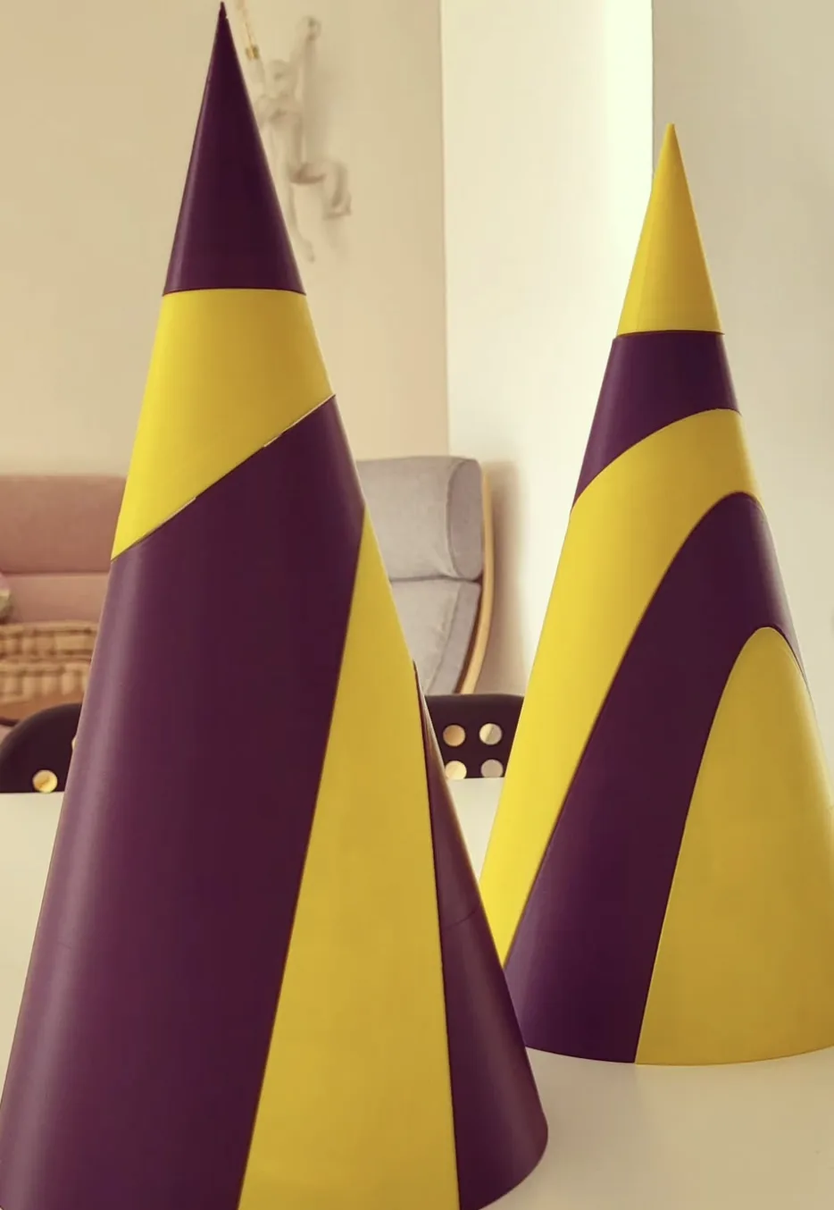 Dos objetos decorativos cónicos morados y amarillos impresos en 3D